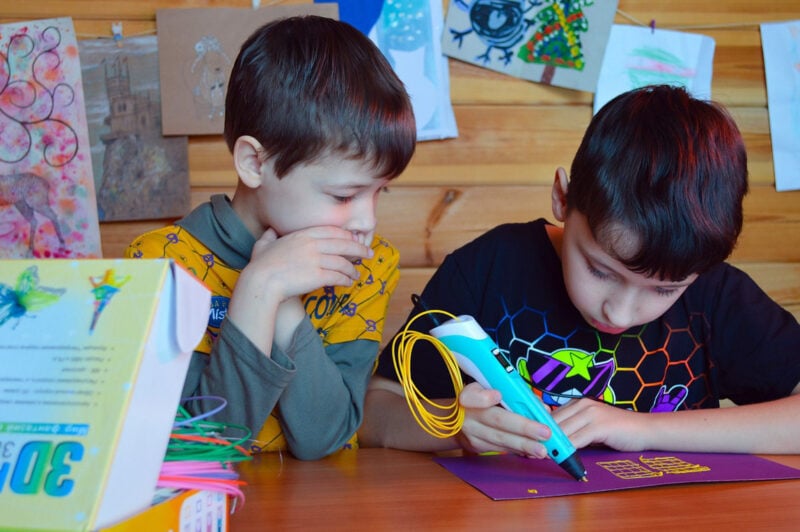 Two children using a 3D pen with either PCL or PLA filament