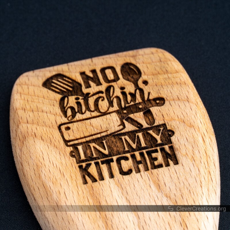 A kitchen spatula that has been engraved with the text No Bitchin in my Kitchen