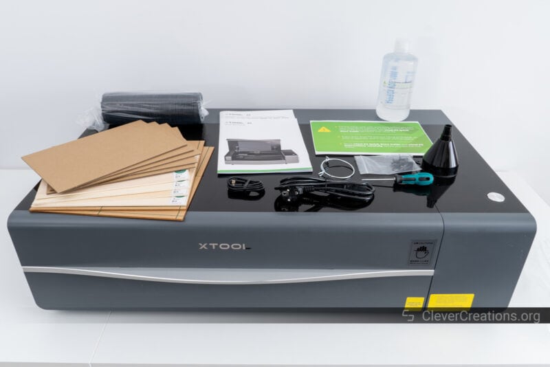 Materials, accessories, and documentation on top of an xTool laser cutter