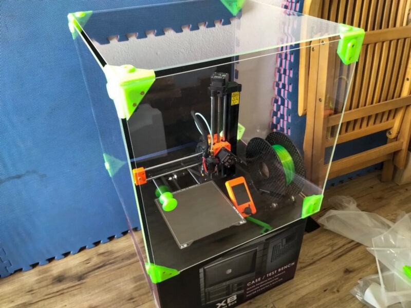 A Prusa 3D Printer in a DIY enclosure made from acrylic and 3D printed brackets.