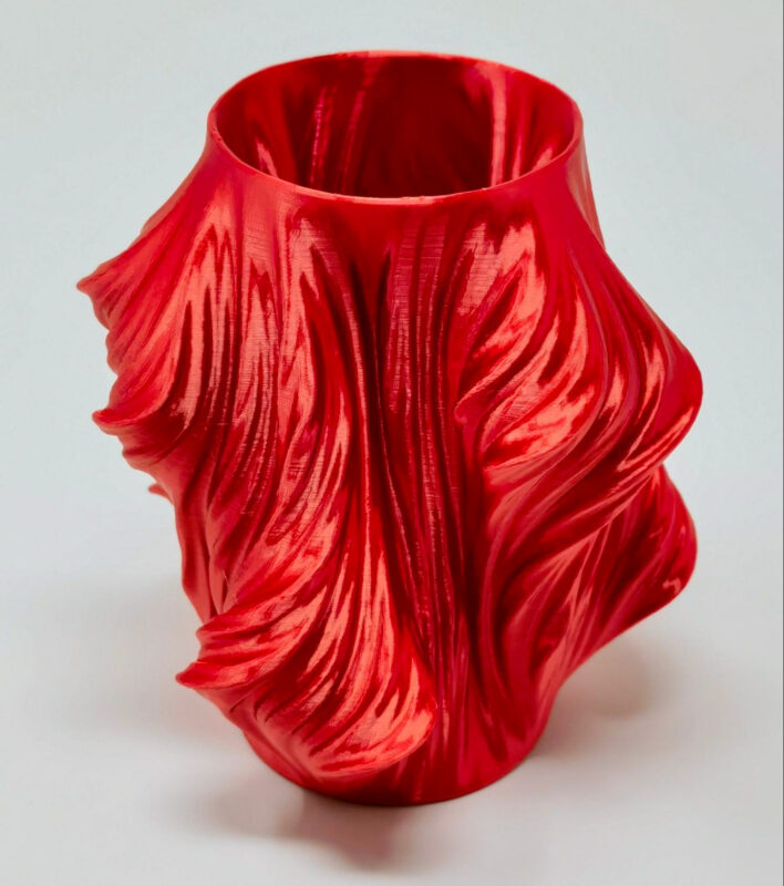 A red 3D print made with Cura vase mode.