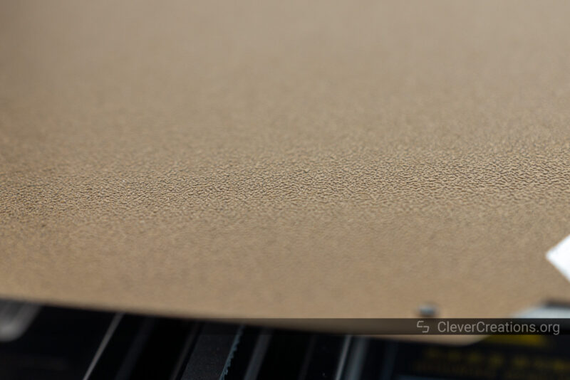A close-up of a PEI-coated print bed surface.