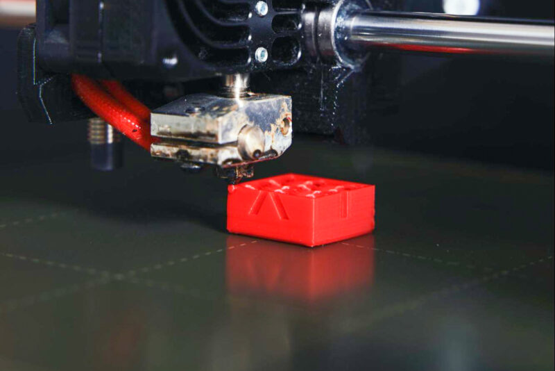 A 3D printer hot end in the process of creating a calibration cube.