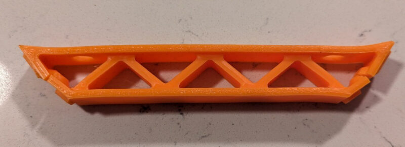 A broken bracket that shows one of the weak PLA filament material properties.