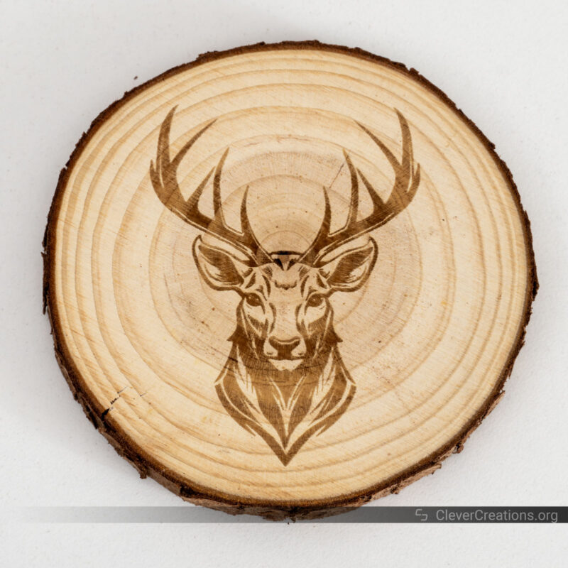 A round wooden coaster with a laser engraved deer head.