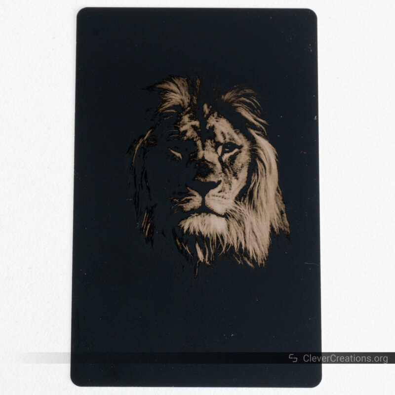 An image of a lion that has been engraved on a metal business card with the xTool F1.