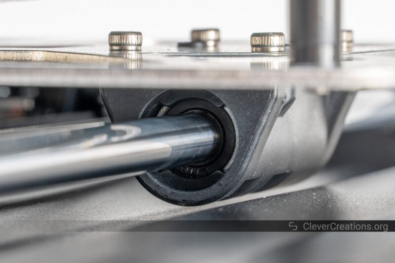 Close-up of a LM08UU linear bearing on a linear rod under a print bed.