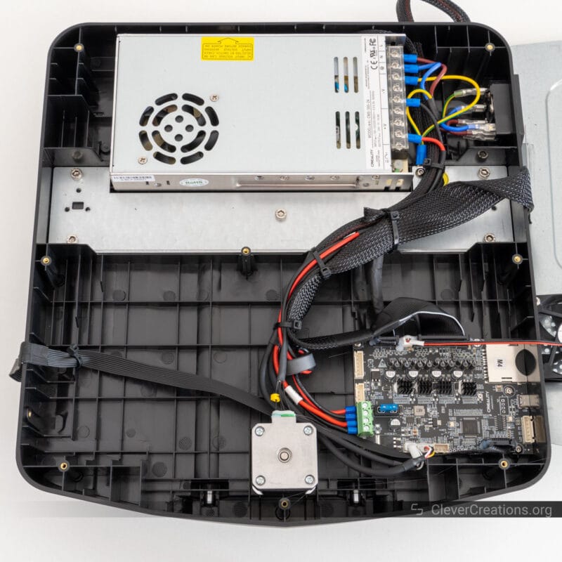 The underside of a 3D printer opened with all of its electronics components visible.