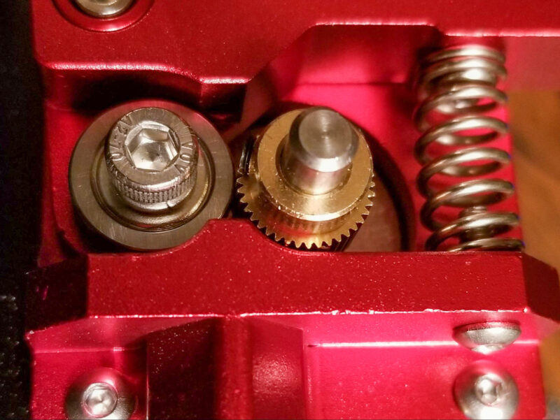 A close-up of the extruder gear and idler bearing in a Bowden extruder.