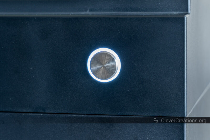 A close-up of a power button with annular color LED ring.