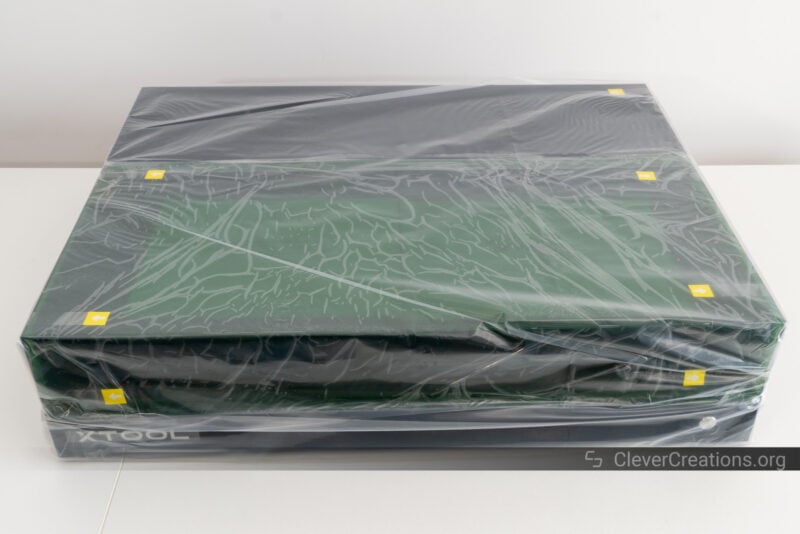 A plastic wrapped laser machine on a table.