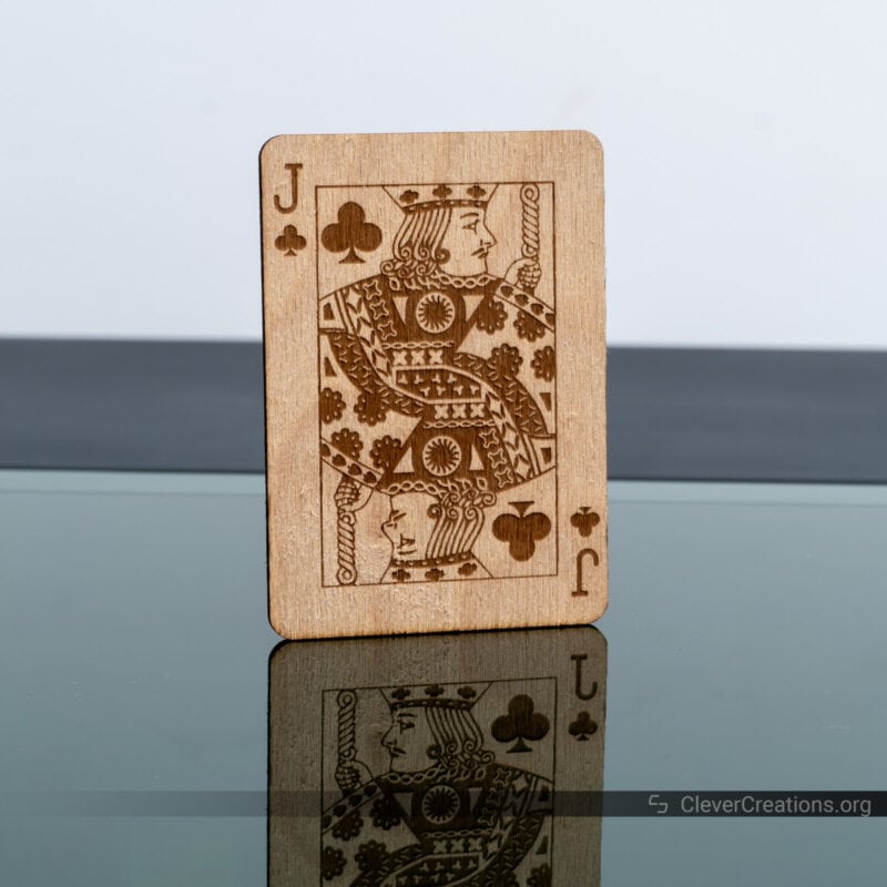A laser cut and engraved business card of a Jack of clubs from beech wood.