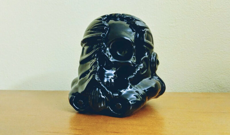A 3D printed black stormtrooper helmet with exposed skull that has been smoothed with Acetone.