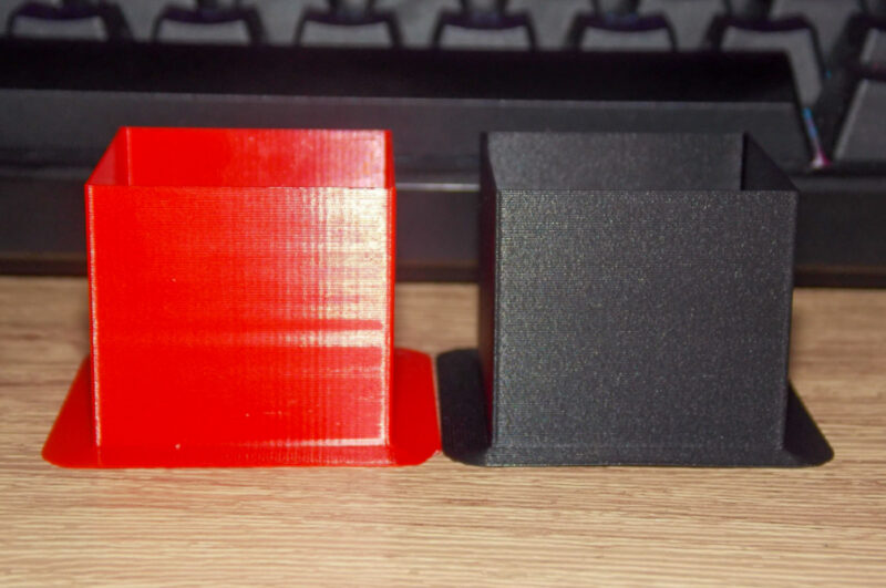 Two red and black print tests in ABS and ASA filament.