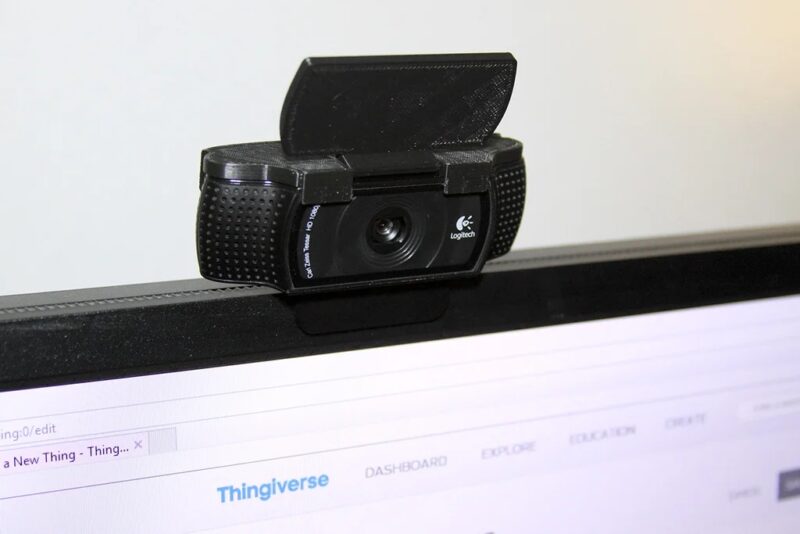 A Logitech C920 camera with 3D printed cover on top of a monitor.