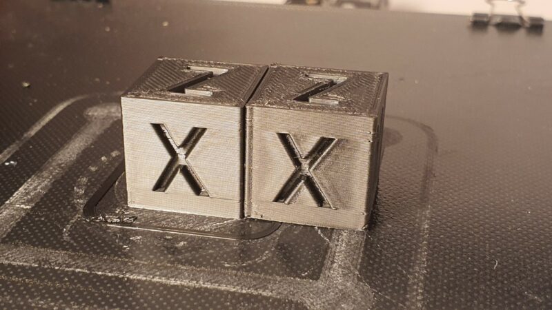Two calibration cubes, one with bulging corners, the other without.
