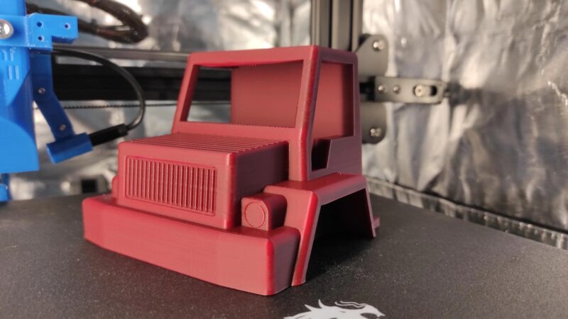 A red 3D printed truck cabin.