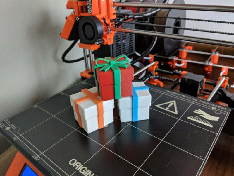 A collection of 3D printed gift boxes on a print bed.