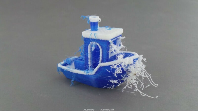 A blue and white 3DBenchy with lots of stringing and oozing.